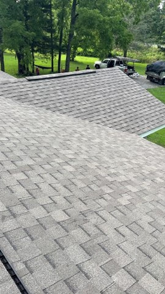 Close view across two new shingle roof planes meeting at the ridge