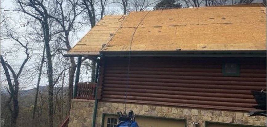 Log cabin on Signal Mountain with the old roof torn off, down to bare plywood decking